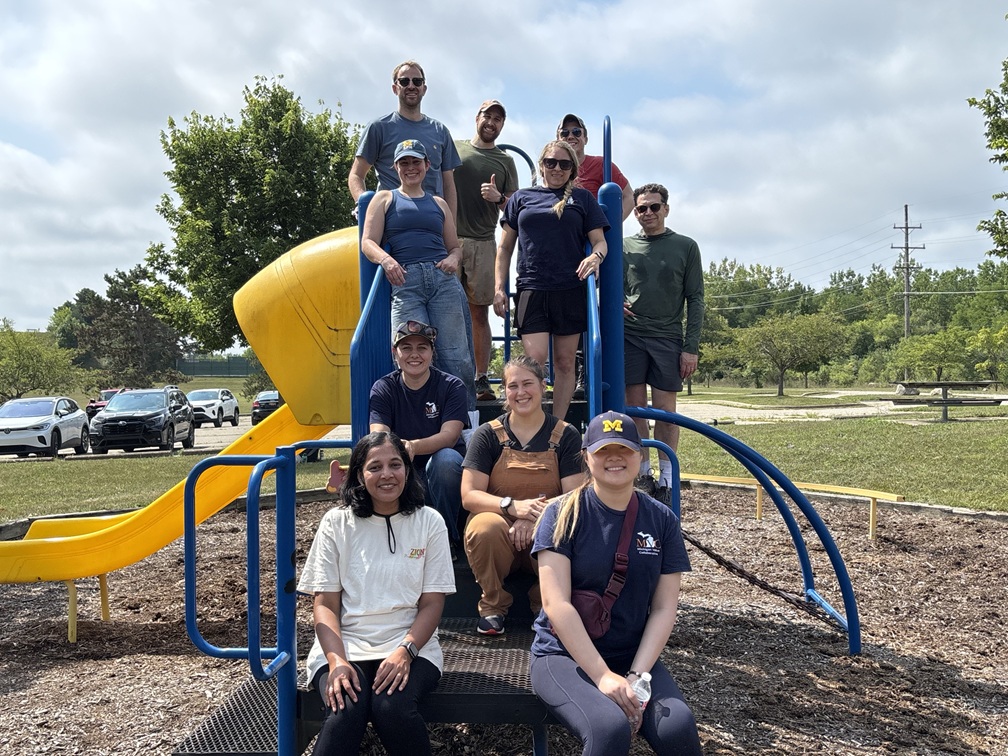 Photograph of MVC Coordinating Center team volunteering with Ann Arbor Parks and Recreation at Leslie Park posing on and around playground equipment.